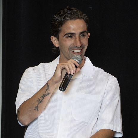 Close-up of Luca speaking into a microphone.