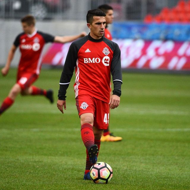 Luca with the ball in a red and black Toronto FC #45 kit.